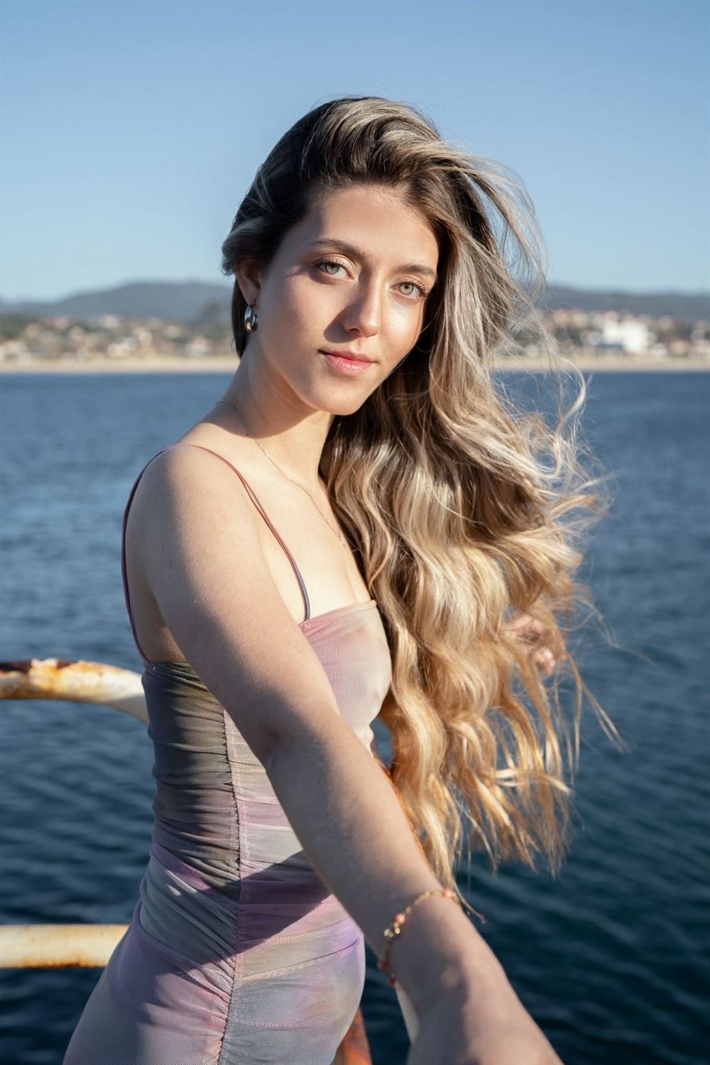 Melena larga rubia con ondas, frente al mar en Vigo